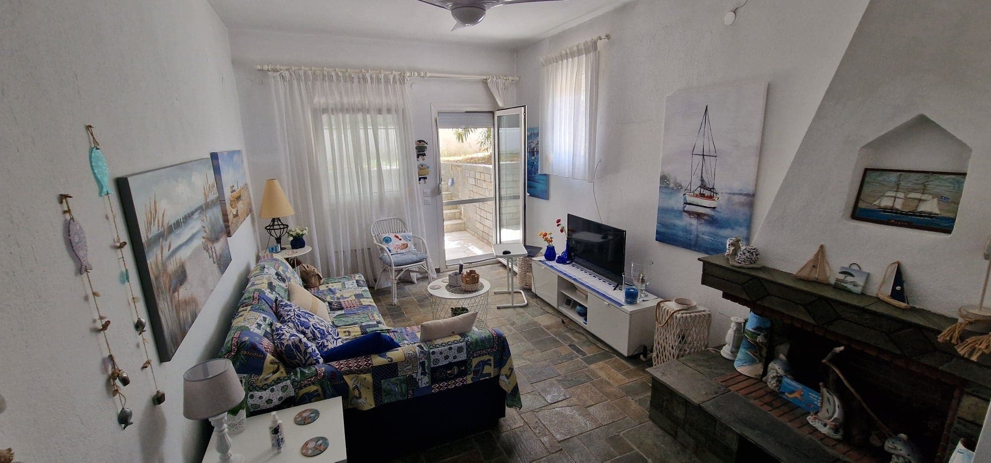 Modern interior of a Greek coastal house with white stone floors and minimalist summer decor